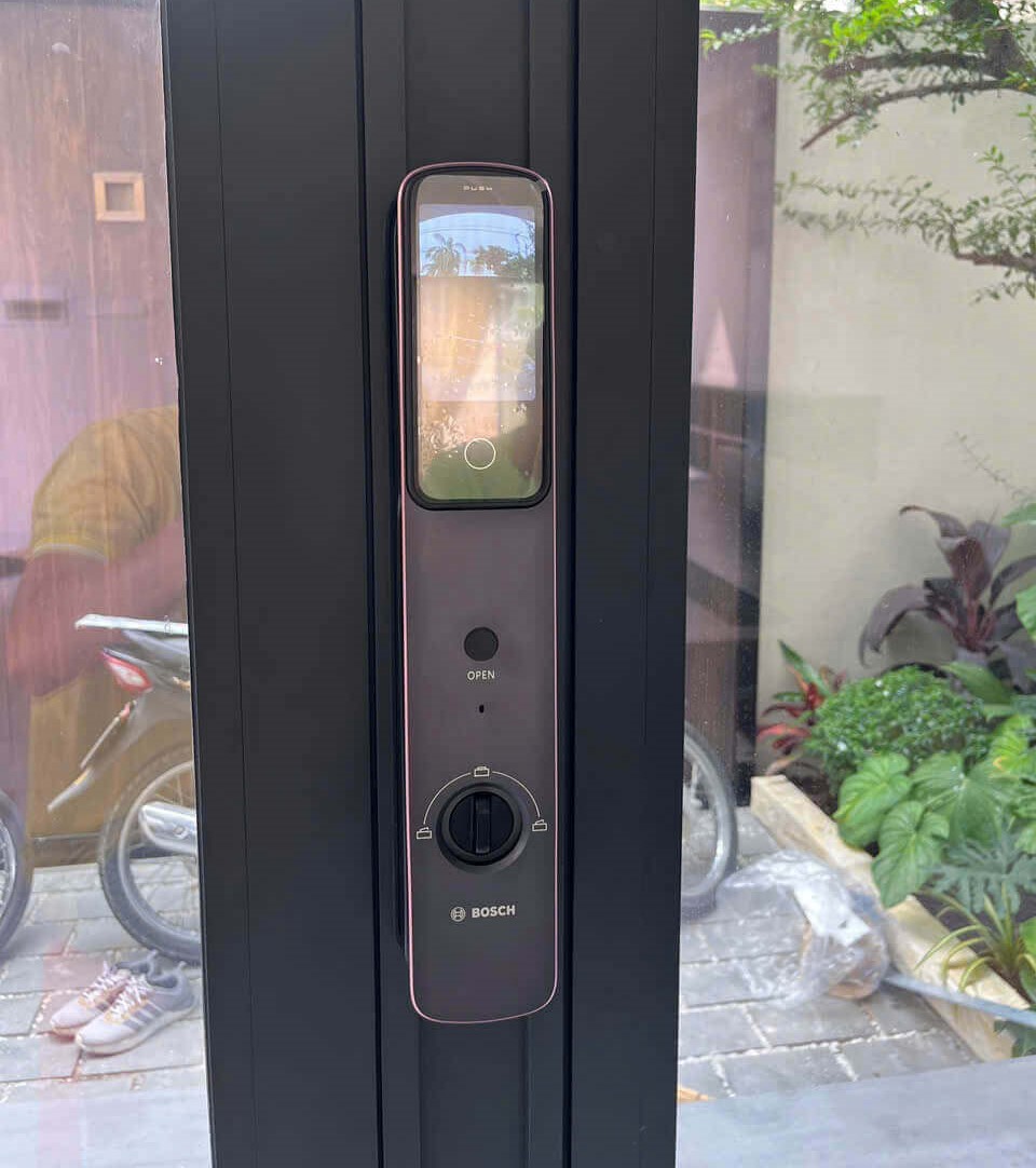 Bosch electronic door lock professionally installed on an aluminum-framed glass door